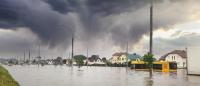Photo of a flooded residential area with dark storm clouds
